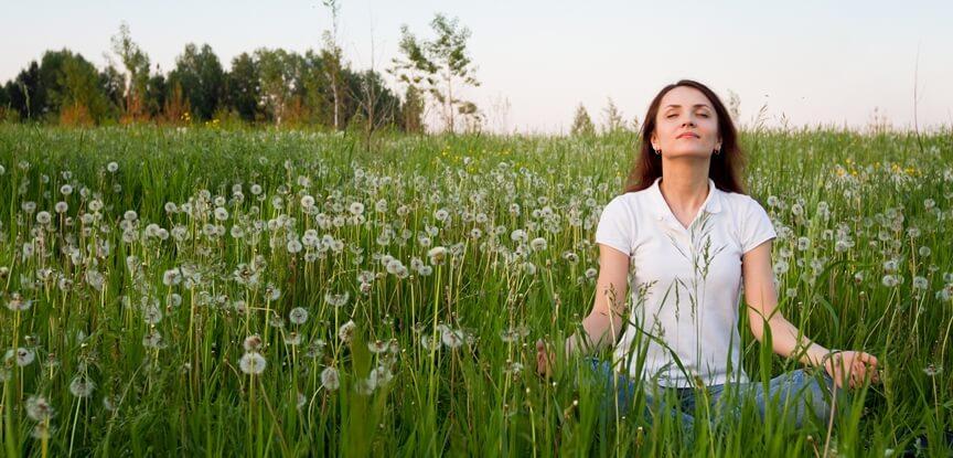 mulher meditando na grama