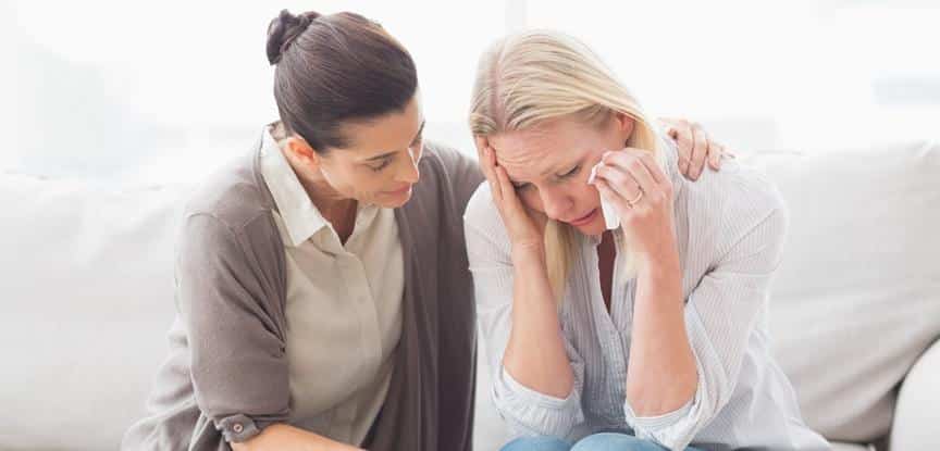 mulher chorando e parente consolando