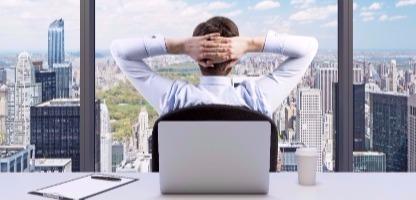 Vista traseira do empresário relaxante com as mãos cruzadas atrás da cabeça, quem está a olhar para o parque Central. Panorâmica de escritórios ou local de trabalho, com vista para cidade de Nova York