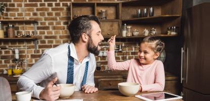 Filha de pai de alimentação com cereais de manhã