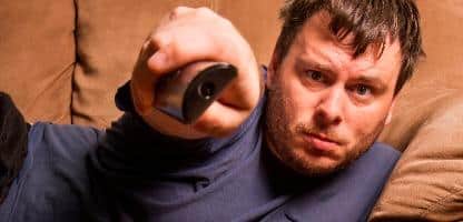 Homem sedentario assistindo tv